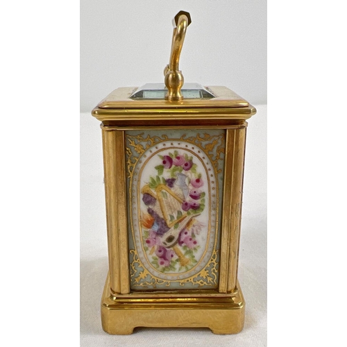 1206 - A miniature brass cased carriage clock with hand painted porcelain panels. Bevel edged glass, gilt d... 