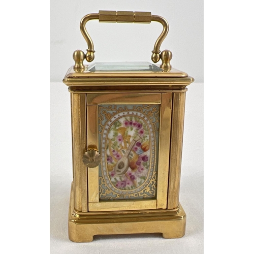 1206 - A miniature brass cased carriage clock with hand painted porcelain panels. Bevel edged glass, gilt d... 