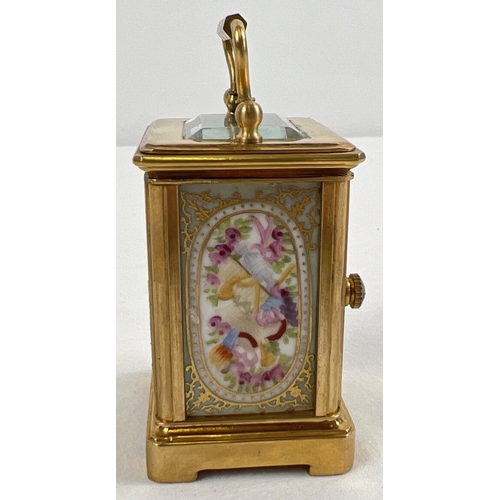 1206 - A miniature brass cased carriage clock with hand painted porcelain panels. Bevel edged glass, gilt d... 