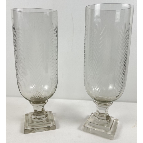 1234 - A pair of cut glass vases raised on pedestal stems with foliate design. Approx. 34cm tall.