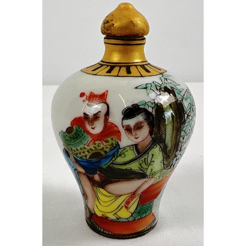 1260 - A small Chinese ceramic snuff bottle with painted erotic scene. Gilt painted stopper and top rim. Ha... 