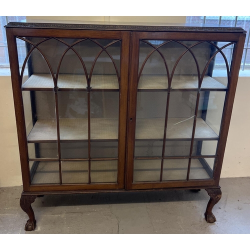 1394 - A vintage dark wood 2 door glass display cabinet raised on 4 ball & claw footed legs. Fabric lined i... 