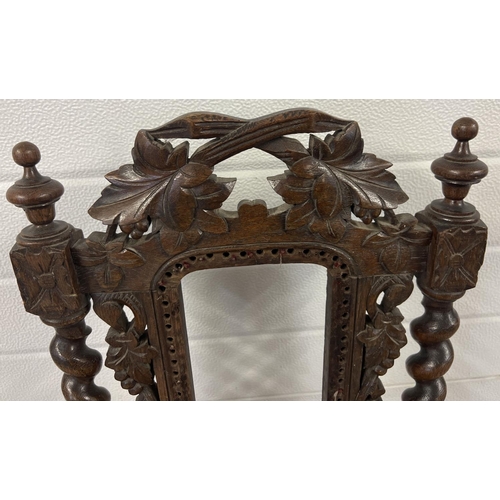 1395 - An antique dark wood hall chair with barley twist columns and carved vine leaf detail. With loose wo... 