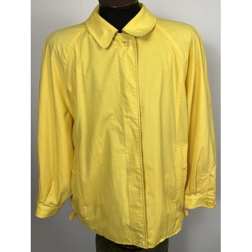 1330 - A ladies Burberrys yellow lightweight jacket. Front zip fastening with button cuffs and side adjusti... 