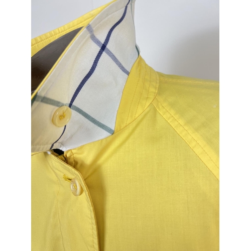 1330 - A ladies Burberrys yellow lightweight jacket. Front zip fastening with button cuffs and side adjusti... 