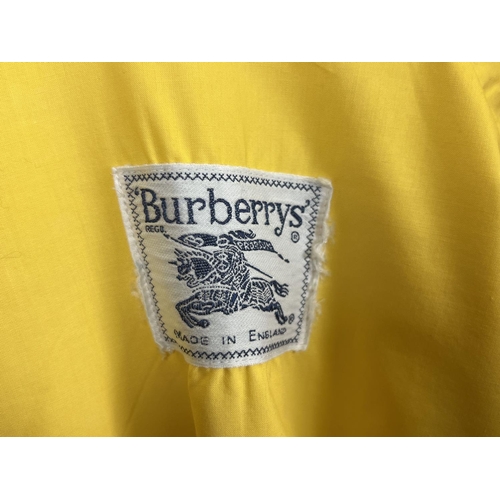 1330 - A ladies Burberrys yellow lightweight jacket. Front zip fastening with button cuffs and side adjusti... 