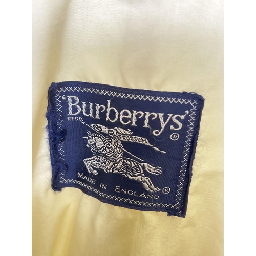 1331 - A cream light weight belted trench coat by Burberrys. Front button fastening with 2 front pockets. B... 