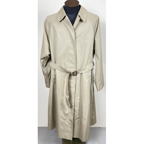 1332 - A beige belted long trench coat by Burberrys. Classic check full length lining, button front fasteni... 