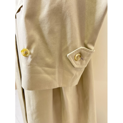 1332 - A beige belted long trench coat by Burberrys. Classic check full length lining, button front fasteni... 