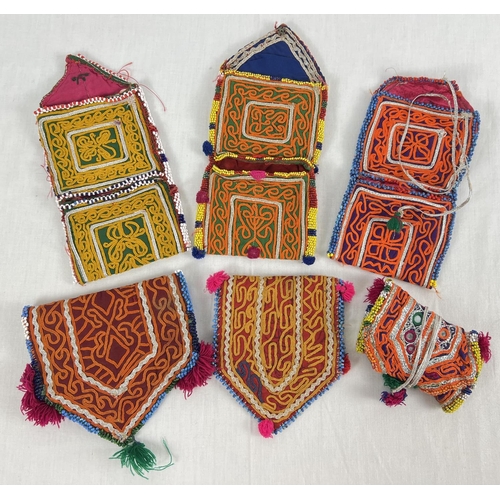 1324 - 6 Central Asian heavily embroidered wrap pouches, in varying colours, sizes and designs. Some with b... 