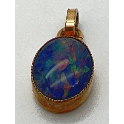 1019 - A 9ct gold oval Australian boulder opal set pendant with closed back. Hallmarks to bale. Approx. 15m... 