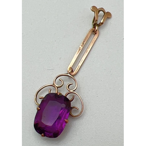 1064 - An Art Noveau 9ct rose gold drop pendant set with an emerald cut amethyst. Scroll work mount surroun... 