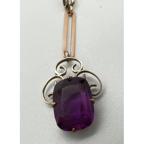 1064 - An Art Noveau 9ct rose gold drop pendant set with an emerald cut amethyst. Scroll work mount surroun... 