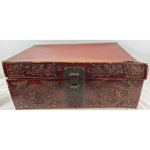 1288 - A vintage red leather trunk with Oriental floral & character relief design to front & sides. Drop me... 