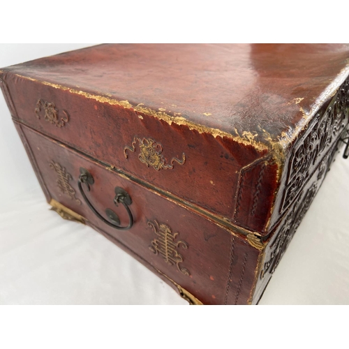 1288 - A vintage red leather trunk with Oriental floral & character relief design to front & sides. Drop me... 