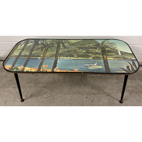 1348 - A mid century glass topped coffee table with screw in legs and adjustable feet. Top decorated with a... 