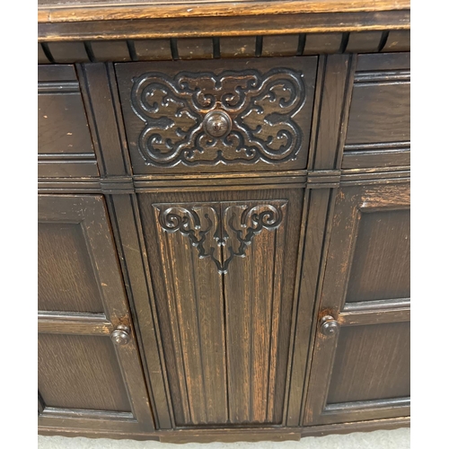 1364 - A vintage dark wood Old Charm style sideboard with carved detail and panelled doors. 2 cupboards to ... 