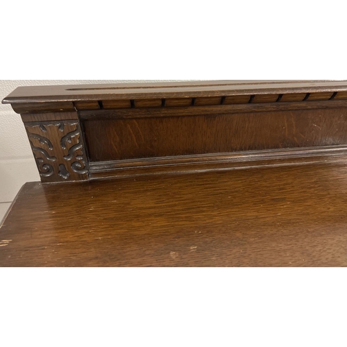 1364 - A vintage dark wood Old Charm style sideboard with carved detail and panelled doors. 2 cupboards to ... 