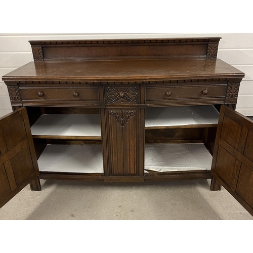 1364 - A vintage dark wood Old Charm style sideboard with carved detail and panelled doors. 2 cupboards to ... 