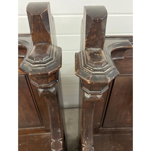 1365 - A pair of antique dark oak church sideman's pew chairs. With panelled backs and shaped arms. Each ap... 