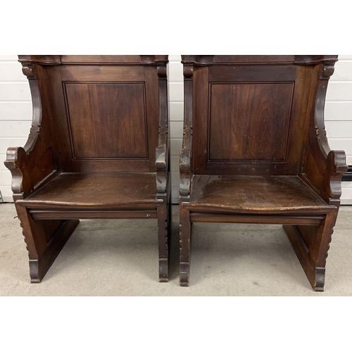 1365 - A pair of antique dark oak church sideman's pew chairs. With panelled backs and shaped arms. Each ap... 