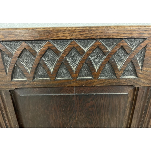 1366 - An antique dark wood high back settle bench with painted crest detail. Panelled back with carved Got... 