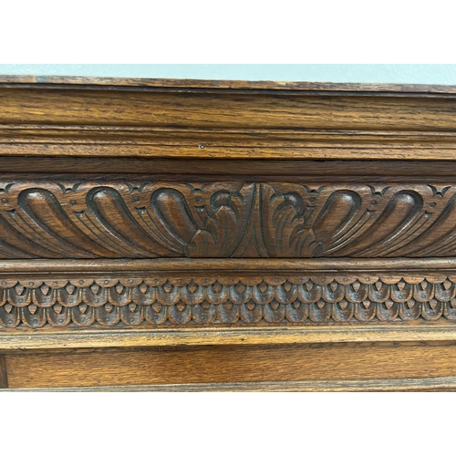 1367 - An antique dark wood wall hanging display cupboard with highly carved detail. With lion head finials... 