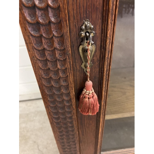 1367 - An antique dark wood wall hanging display cupboard with highly carved detail. With lion head finials... 