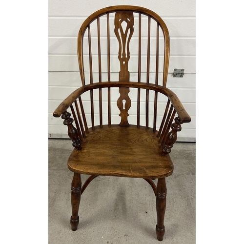 1374 - An antique spindle backed yew wood Windsor chair with curved stretcher and turned supports.