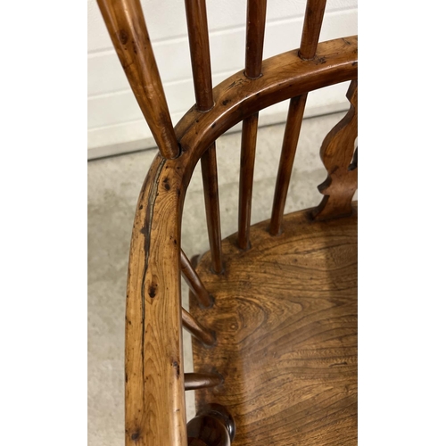 1374 - An antique spindle backed yew wood Windsor chair with curved stretcher and turned supports.