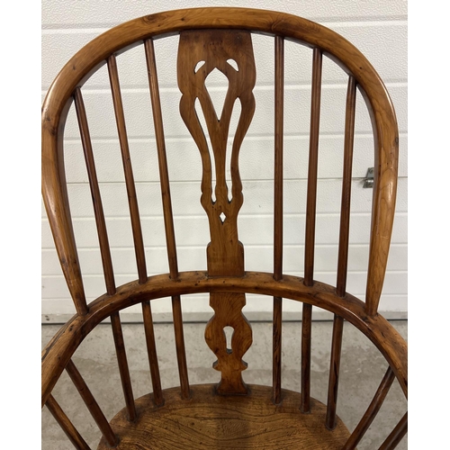 1374 - An antique spindle backed yew wood Windsor chair with curved stretcher and turned supports.