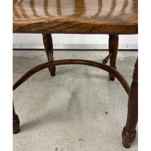 1374 - An antique spindle backed yew wood Windsor chair with curved stretcher and turned supports.