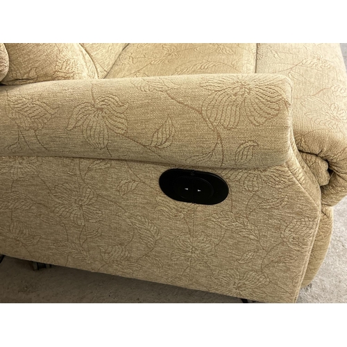 1375 - A modern T Motion electric recliner armchair with cream coloured floral upholstery. Complete with po... 