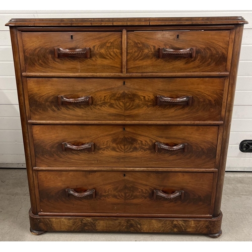 1387 - An antique wood 2 over 3 chest of drawers with decorative wooden looped handles. Raised on bun feet,... 