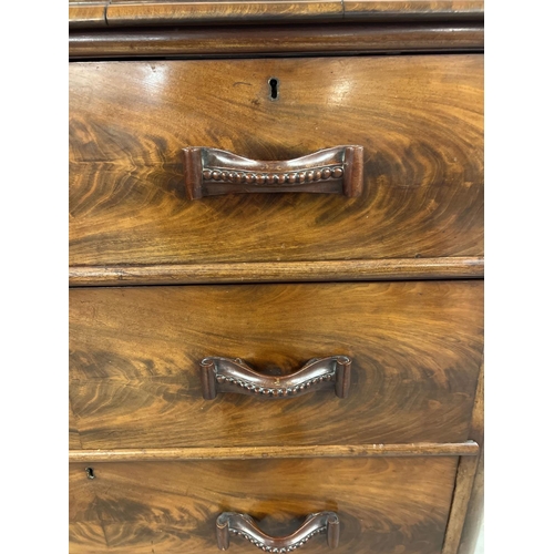 1387 - An antique wood 2 over 3 chest of drawers with decorative wooden looped handles. Raised on bun feet,... 