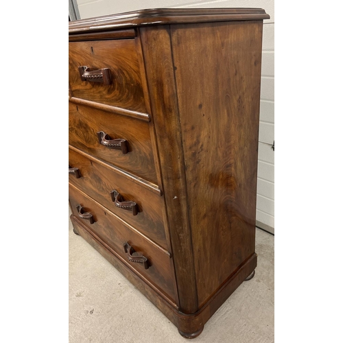 1387 - An antique wood 2 over 3 chest of drawers with decorative wooden looped handles. Raised on bun feet,... 