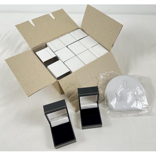 1066 - A box containing 11 new ring boxes in card sleeves, together with an unopened 3 ring display stand. ... 