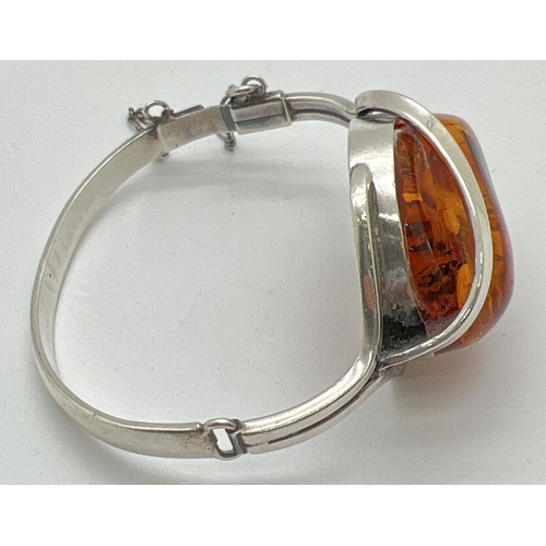 1005 - A modern design silver and Baltic amber bangle style bracelet with safety chain. Large central piece... 