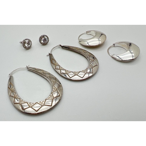 1076 - 3 pairs of silver earrings. A stud style pair set with clear round cut stones, a pair of modern bubb... 