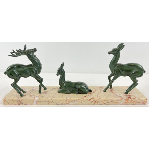 1291 - A French Art Deco marble & onyx based mantel figurine of 3 spelter deer. A seated deer flanked by a ... 