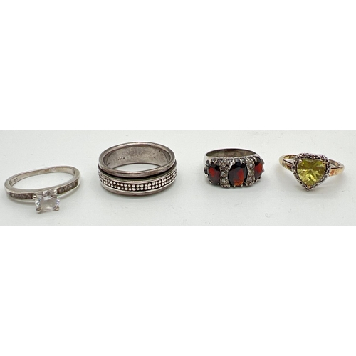 1080 - 4 silver dress rings. A silver spinner band ring; a vintage garnet set eternity style ring; a heart ... 