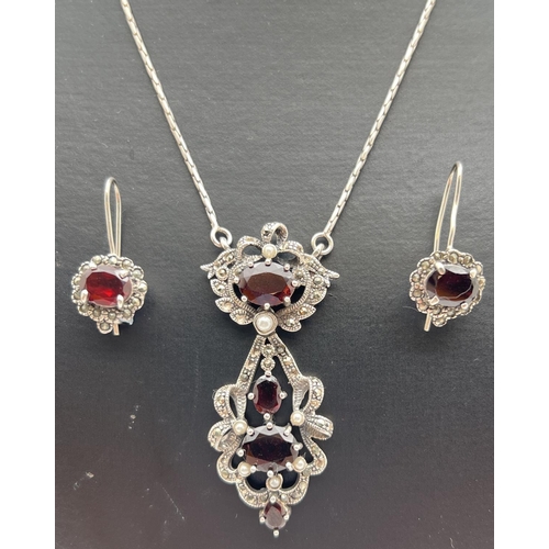 1085 - A Gothic style fixed drop pendant necklace set with garnets, faux pearls and marcasite stones. Toget... 