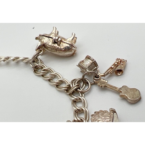 1093 - A vintage double belcher chain charm bracelet with padlock, safety chain & 7 charms. Silver marks to... 