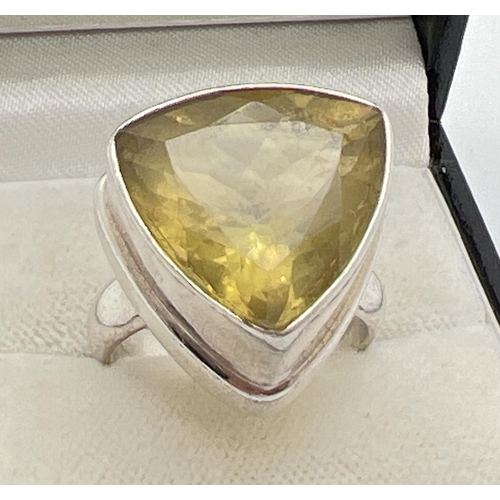 1101 - A modern design silver statement dress ring set with a trillion cut yellow citrine. Inside of band m... 