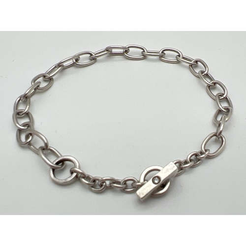 1104 - A modern design belcher chain style bracelet with T bar clasp. T Bar set with a small round cut diam... 