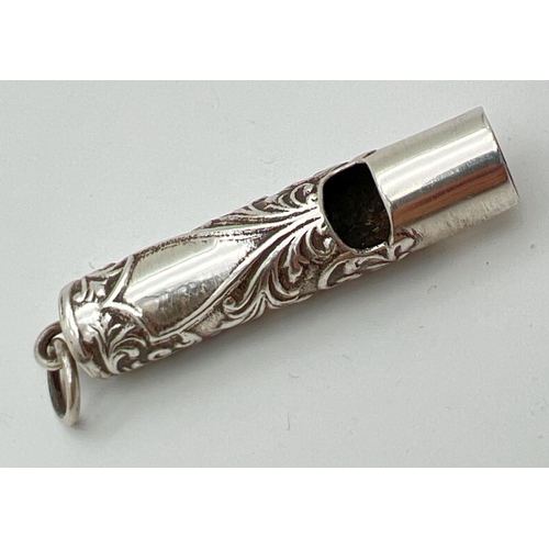 1183 - A small silver whistle with scroll and floral decoration and empty cartouche. Silver mark to undersi... 