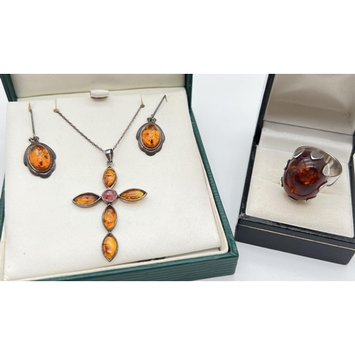 1108 - A collection of silver and amber jewellery items. A cross shaped pendant with central pink coloured ... 