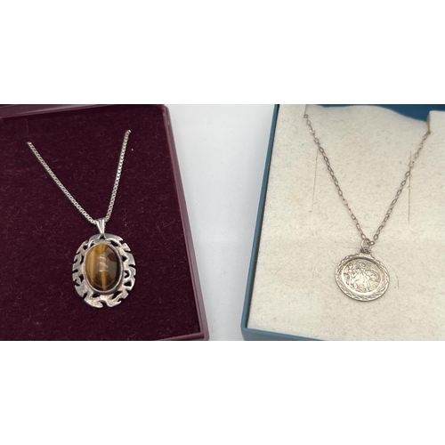 1112 - 2 boxed silver pendant necklaces. An oval cabochon of Tigers Eye in a Celtic style mount, fully hall... 