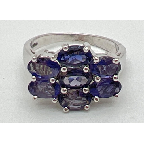 1119 - A silver dress ring set with 7 oval cut amethyst stones. Band fully hallmarked, ring size O½. Each s... 