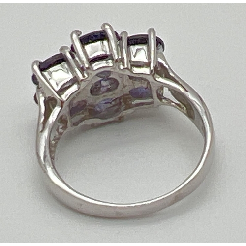 1119 - A silver dress ring set with 7 oval cut amethyst stones. Band fully hallmarked, ring size O½. Each s... 